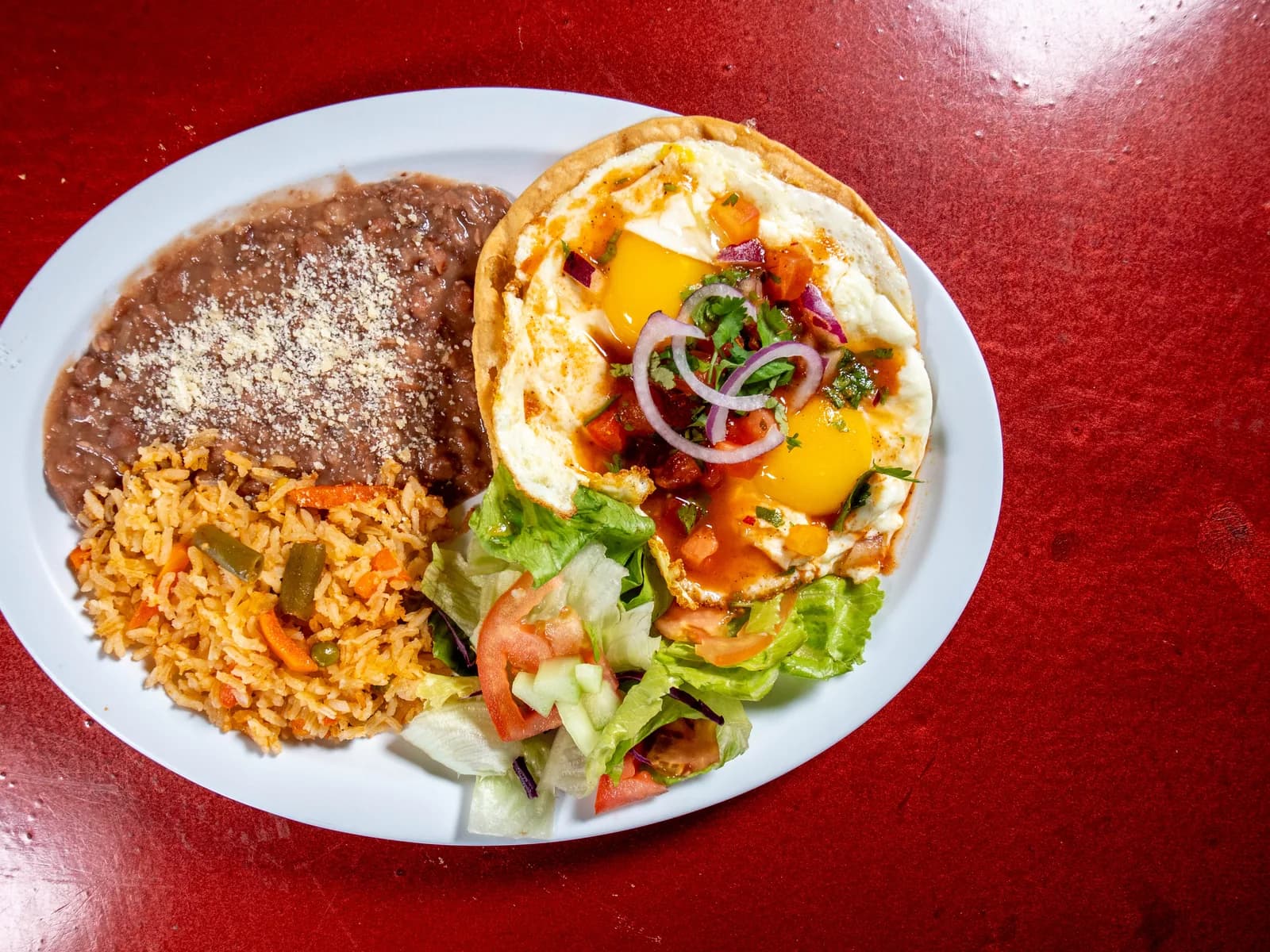 Huevos Rancheros with beans, rice, salad and tortillas