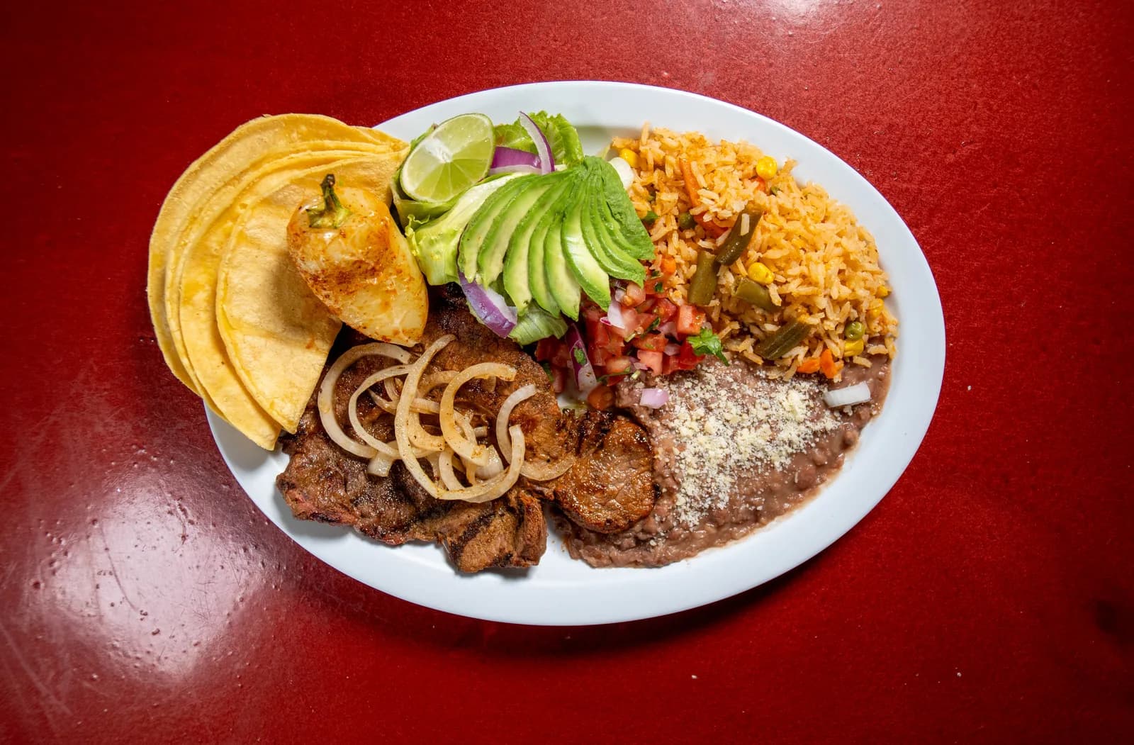Carne asada plate with rice, beans, tortillas and avocado