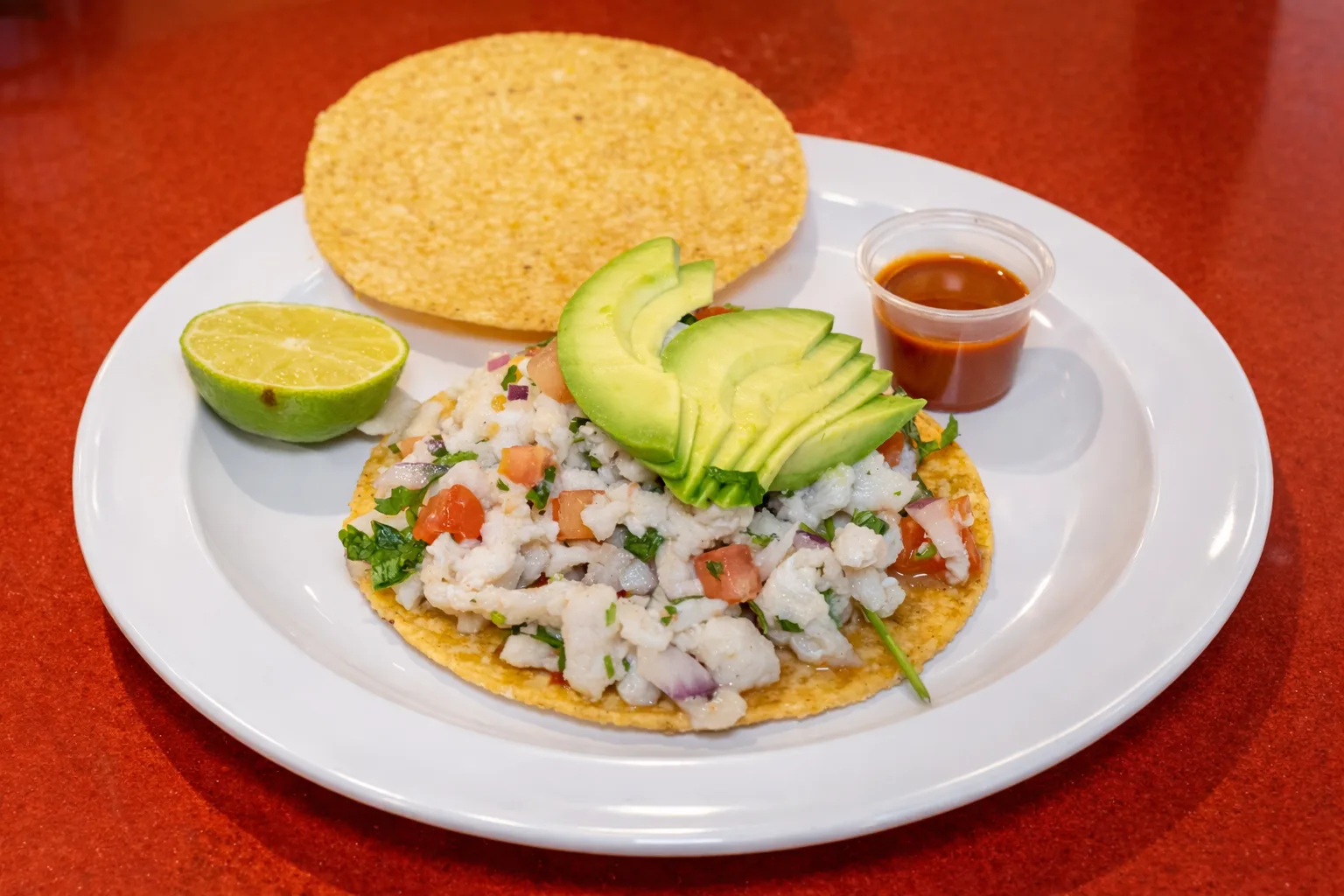 Ceviche tostada with avocado, lime and salsa