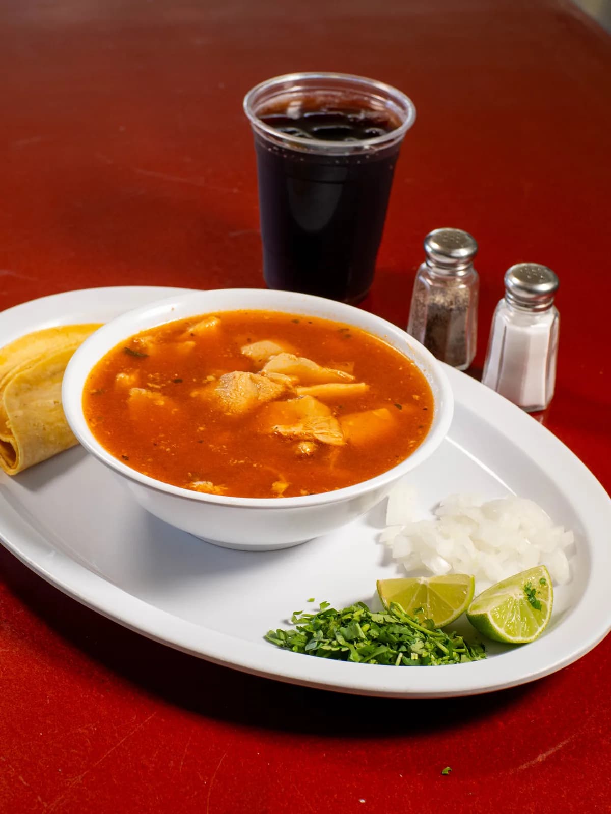 Menudo with lime, onion, cilantro and tortillas